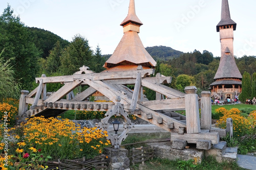 Barsana Monastery, Maramures, Romania, Europe, spring 2018. Celebration of August 14 in the afternoon at the Barsana Orthodox Monastery. Beautiful wooden bridge with churches in the distance.