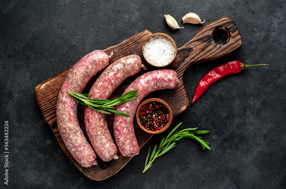raw sausages with spices and rosemary on a stone background raw sausages with spices and rosemary on a stone background