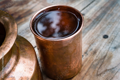 Photography A copper water holder and a glass