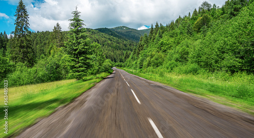 Old asphalt road in a mountain forest. © Denis Rozhnovsky