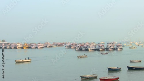 Amazing shot of small boat sailing and stopped yachts and boats in the coastline. photo