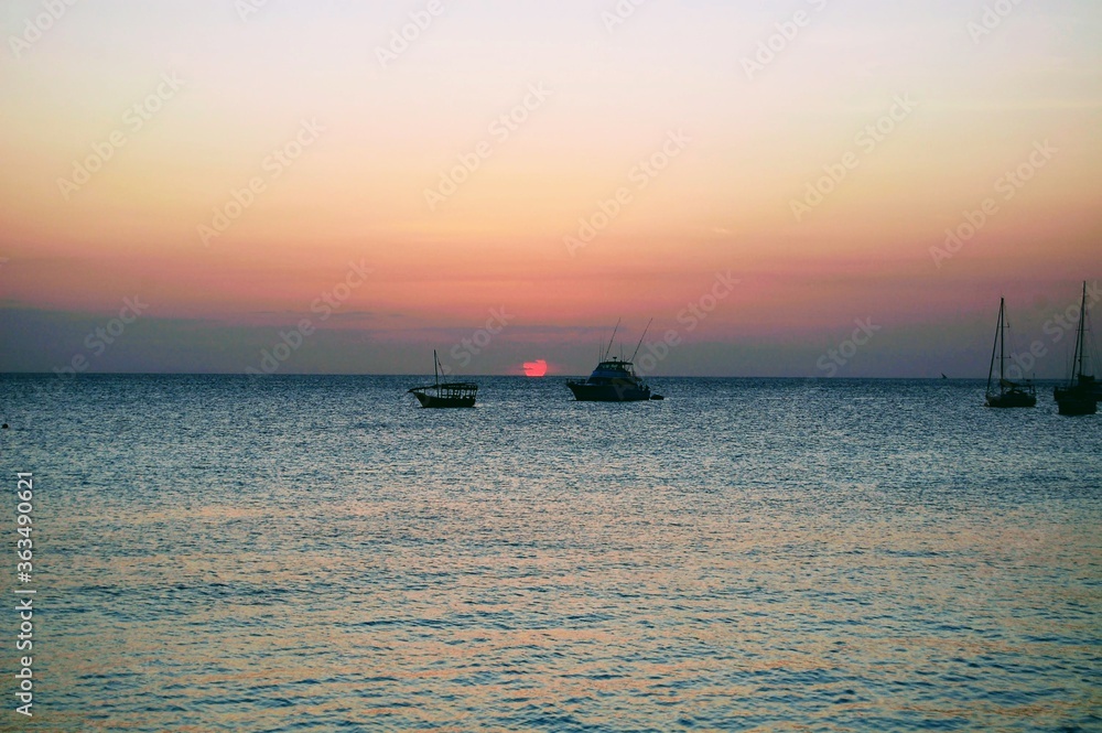 African sunset with boats on the horizon in Zanzibar, Tanzania 