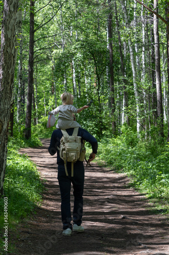 Father walks along a forest trail with his little daughter