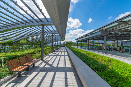 Glass shade corridors in modern parks under the blue sky and white clouds.