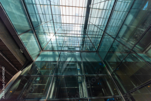 Modern glass elevator and pedestrian stairway entrances.