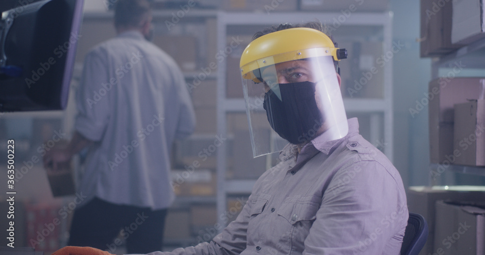 Man wearing protective gear in warehouse Man wearing protective gear in warehouse