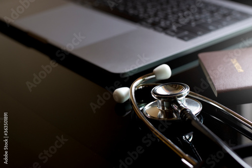 Valokuva Mockup image of medical stethoscope, passport and laptop computer isolated on dark table background