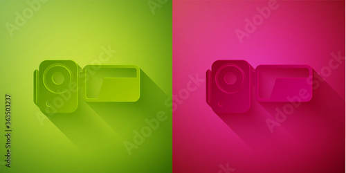 Paper cut Cinema camera icon isolated on green and pink background. Video camera. Movie sign. Film projector. Paper art style. Vector Illustration.