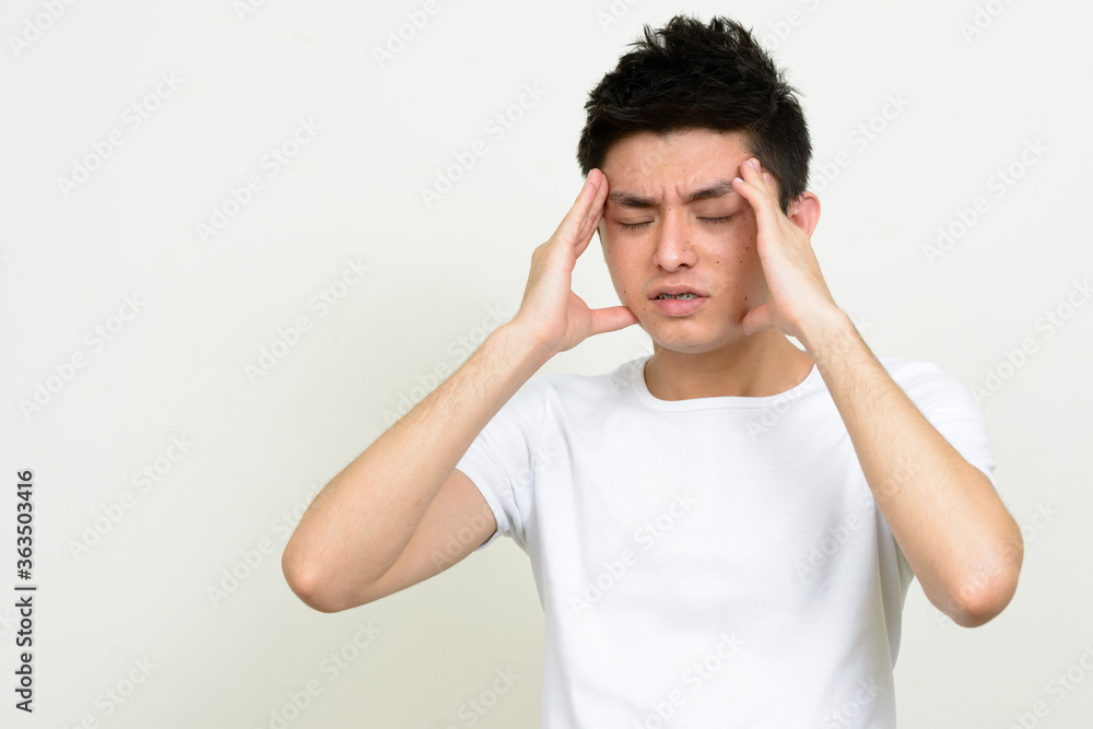 Portrait of stressed young Asian man having headache Portrait of stressed young Asian man having headache
