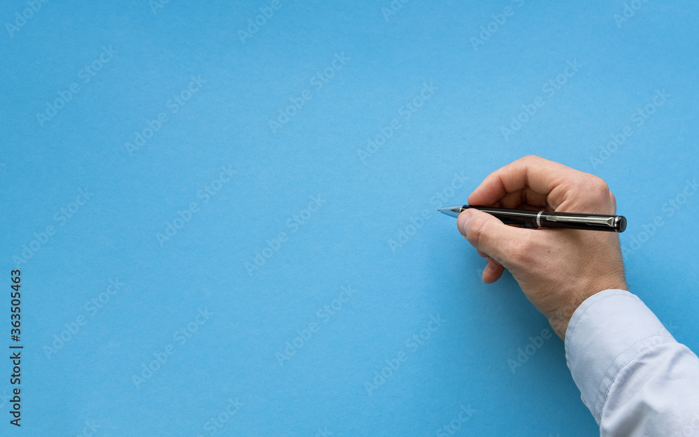 Man hand about to write on blank blue background. Male hand writing on a blank surface with black pen. Close-up hand holding a pen and writing gesture on a background with the clipping path. Man hand about to write on blank blue background. Male hand writing on a blank surface with black pen. Close-up hand holding a pen and writing gesture on a background with the clipping path.