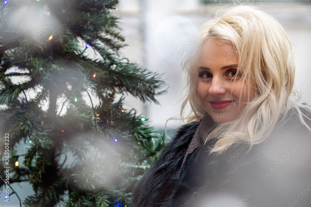 Portrait of a young smiling blonde woman photographed through the Christmas lights, soft focus. Portrait of a young smiling blonde woman photographed through the Christmas lights, soft focus.