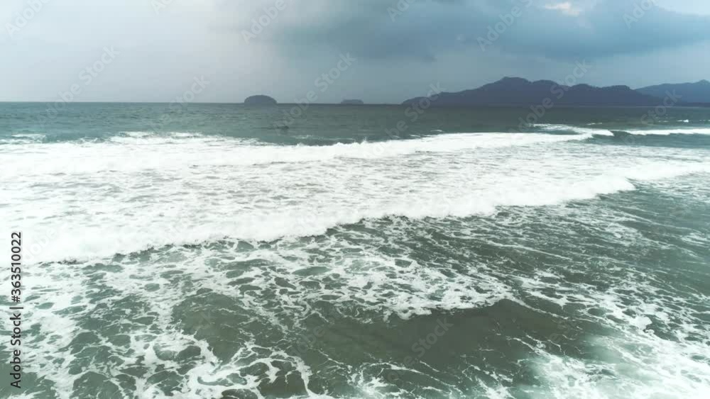 Aerial view of blue ocean with beautiful foaming rolling waves at cloudy day. Travel concept. Nacpan beach, Palawan, Philippines. Aerial view of blue ocean with beautiful foaming rolling waves at cloudy day. Travel concept. Nacpan beach, Palawan, Philippines.