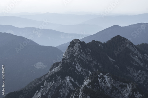 Spectacular view of grey mountain ranges silhouettes and fog in valleys. Julian Alps, Triglav National Park, Slovenia. View from Mountain Slemenova, Sleme. photo