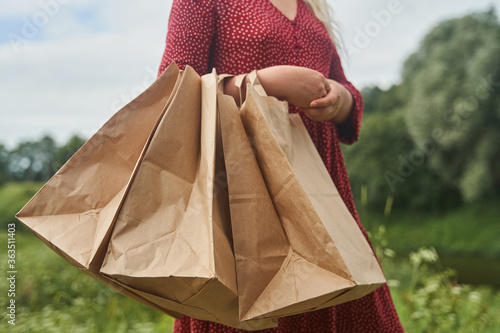 A young girl holds blank paper bags in her hand. Shopping concept. High-quality photo
