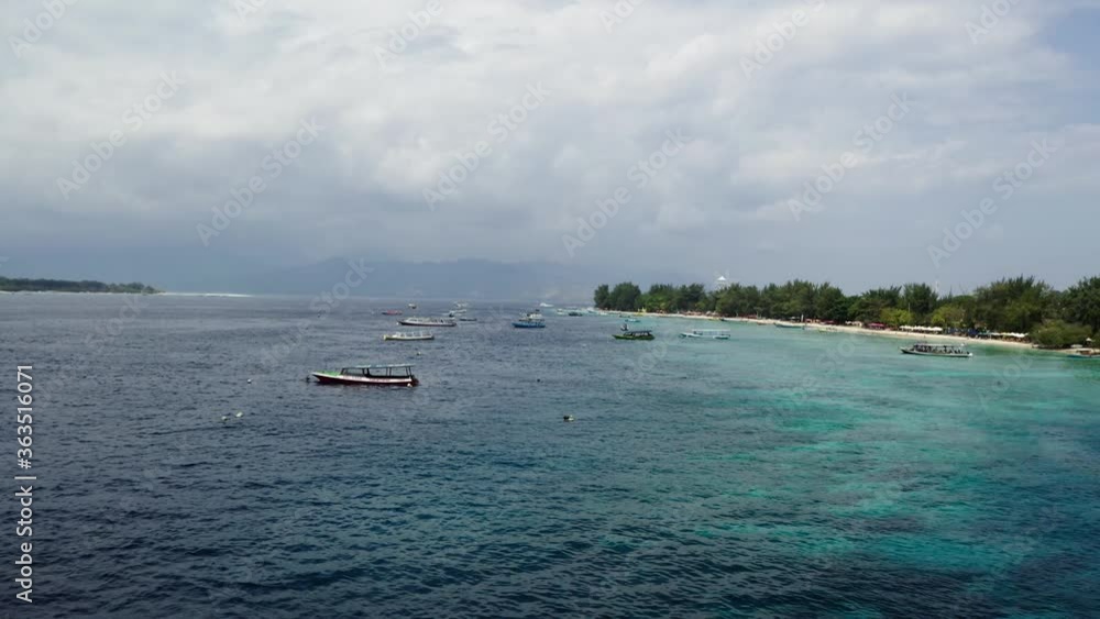 Summer time in the Gili Travangan Island with cruise boats. Aerial drone shot of the island nearby. Summer time in the Gili Travangan Island with cruise boats. Aerial drone shot of the island nearby.