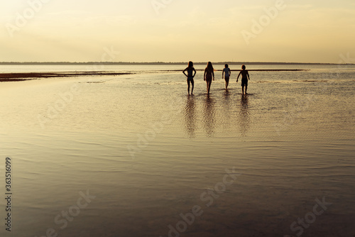 children walking on the beach at sunset