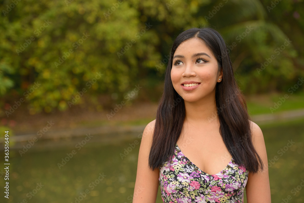 Portrait of happy young beautiful Asian woman thinking at the park Portrait of happy young beautiful Asian woman thinking at the park