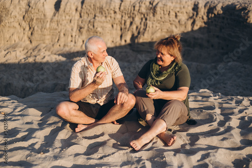 Happy elderly seniors couple retired in summer beach outdoors
