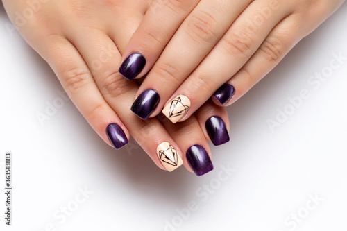Cat s eye dark purple manicure on square long nails closeup on a white background. White ringless finger with a painted fox. Abstraction.
