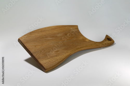 Beautiful carved wooden cutting Board on a white background, made by your own hands.For cooking and decorating the interior of the kitchen area.