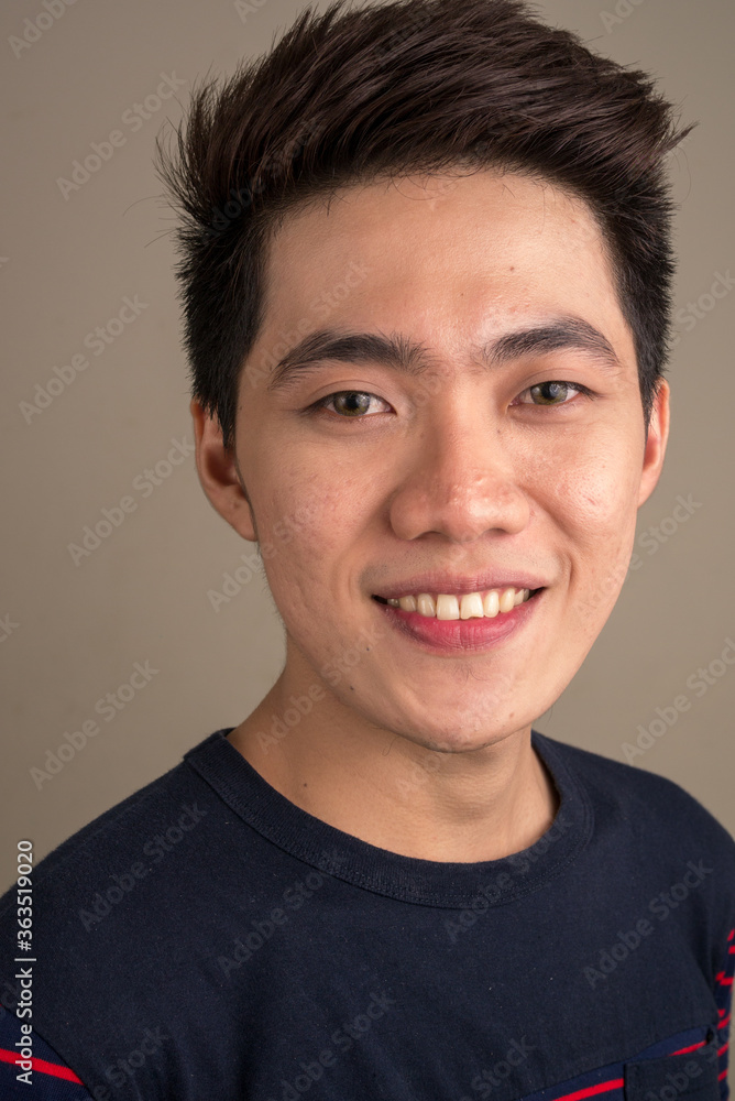 Face of happy young handsome Asian man smiling Face of happy young handsome Asian man smiling