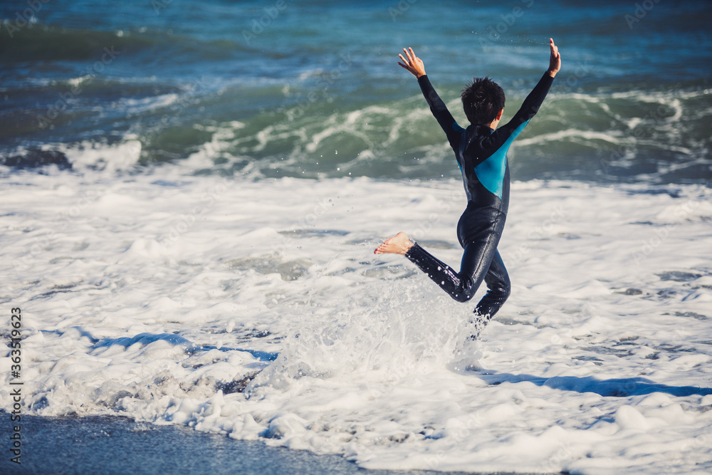 Two friends kids enjoying a funny surf day in the shore of a sunny beach in their coastal holidays Two friends kids enjoying a funny surf day in the shore of a sunny beach in their coastal holidays