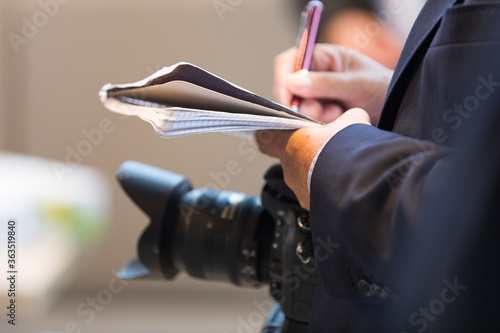 Journalist mit Kamera und Notizblock auf einem Pressetermin photo
