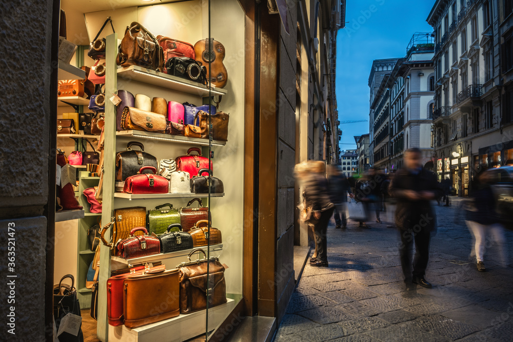 Obraz premium People walking by a luxury bag store in Florence at night