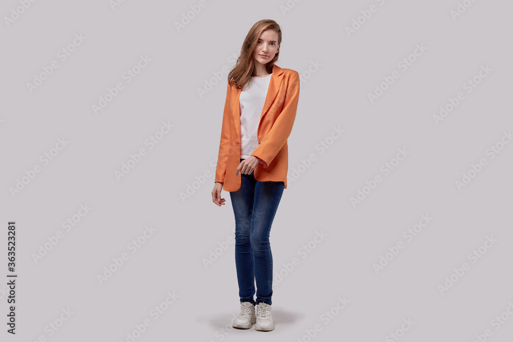 Cute girl in a bright jacket and jeans posing and looking at the camera. Cute girl in a bright jacket and jeans posing and looking at the camera.