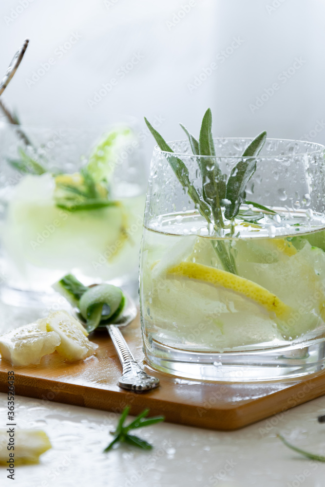 Refreshing iced drink with lemon and fresh rosemary, detox summertime Refreshing iced drink with lemon and fresh rosemary, detox summertime