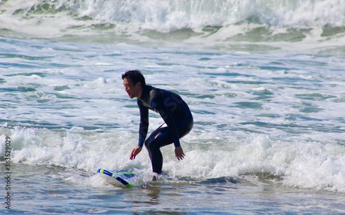 20s man surfing in CA, the US