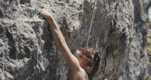 Female paralympic climber woman athlete with missing fingers on left hand struggle and succeed to rock climb hold grip ascend outdoors lifestyle sport in nature