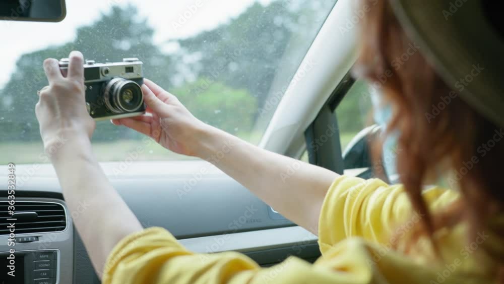 precautions, joyful girl in straw hat and protective medical mask takes selfie on retro camera during family trip on car traveling on summer weekend precautions, joyful girl in straw hat and protective medical mask takes selfie on retro camera during family trip on car traveling on summer weekend