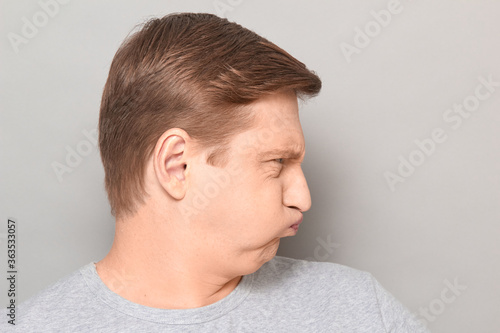Portrait of funny goofy man puffing out his cheeks and pouting lips