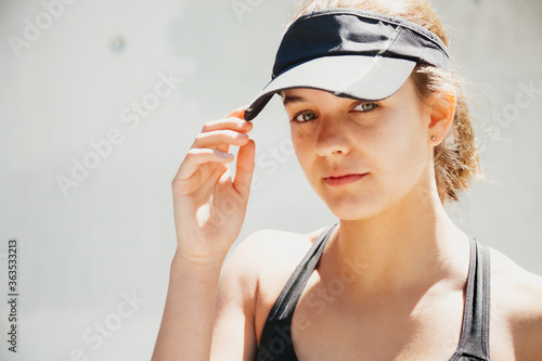 Portrait of a beautiful young sporty woman with visor cap in a warm day