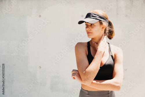 Portrait of a beautiful young sporty woman with visor cap in a hot day photo
