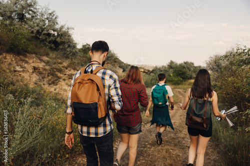 Group of four of tourists hiking in mountains  in a forest.
