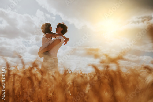mother and daughter hugging in a wheat field under a sunset