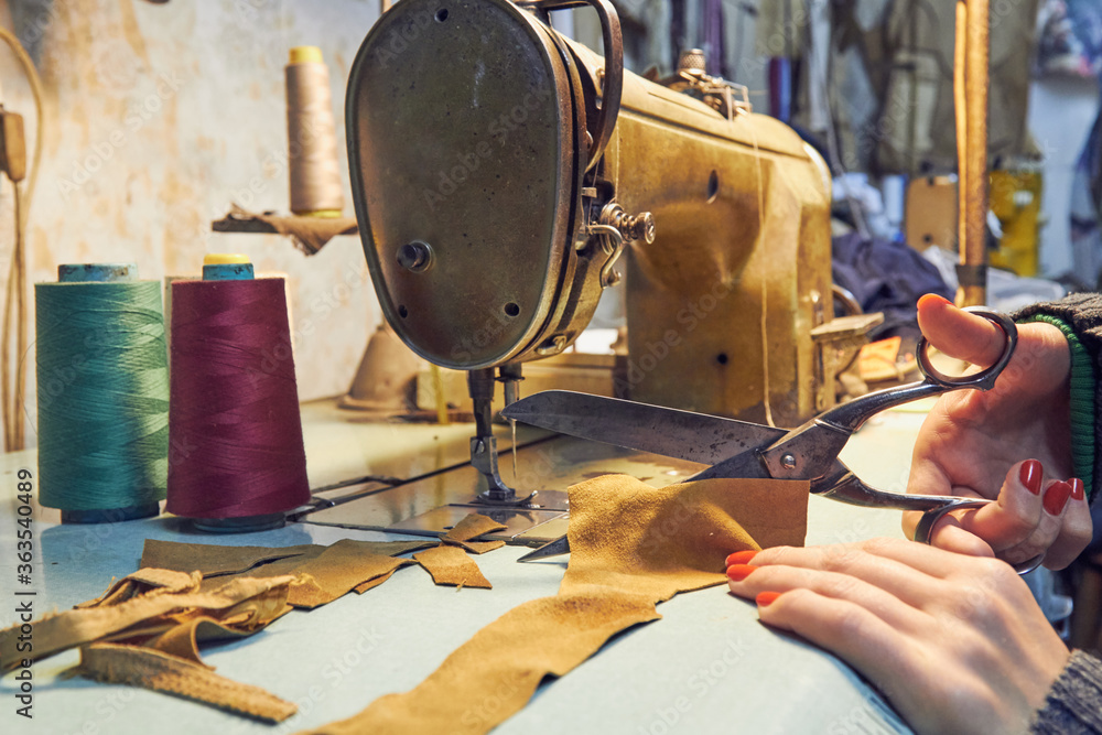 Woman tailor using retro sewing machine at home, hobby concept. Woman tailor using retro sewing machine at home, hobby concept.