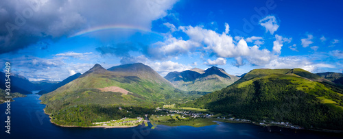 A rainbow appearing over the pap of glencoe and the village of glencoe in the argyll region of the highlands of Scotland during a summer rainfall © Andy Morehouse