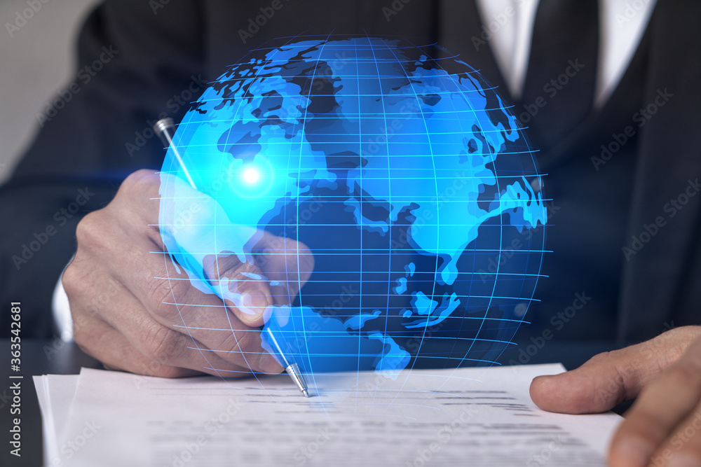 Businessman in suit signs contract. Double exposure with world map hologram. Man signing agreement international business concept. Businessman in suit signs contract. Double exposure with world map hologram. Man signing agreement international business concept.
