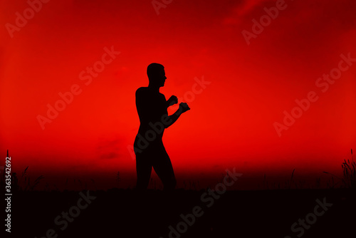 Silhouette of a male fighter engaged in training in nature