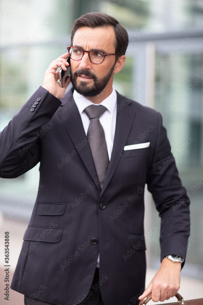 a businessman on the phone walking outdoors a businessman on the phone walking outdoors