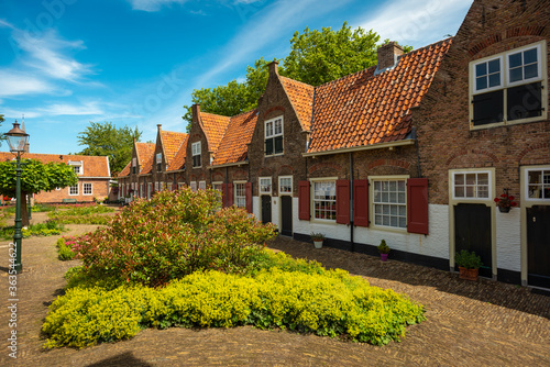 Medieval Dutch almshouses on a sunny summer day with a blue sky