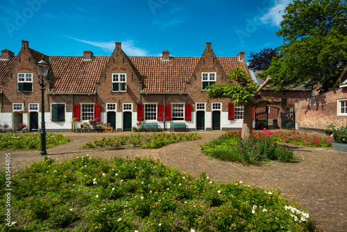 Medieval Dutch almshouses on a sunny summer day with a blue sky