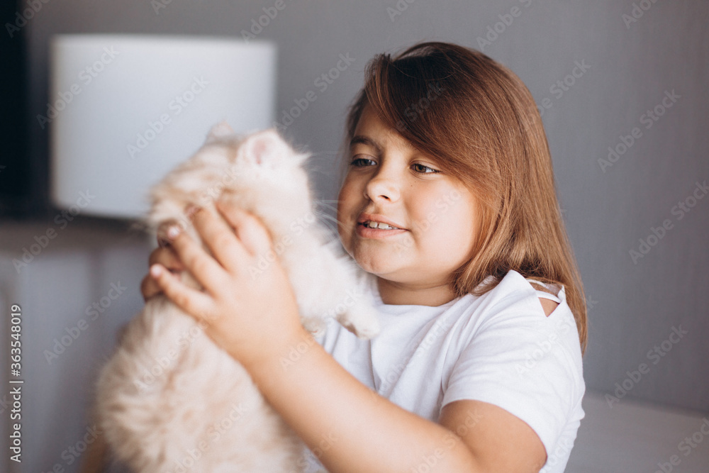 Little girl with small kitten at home. Children and pet Little girl with small kitten at home. Children and pet