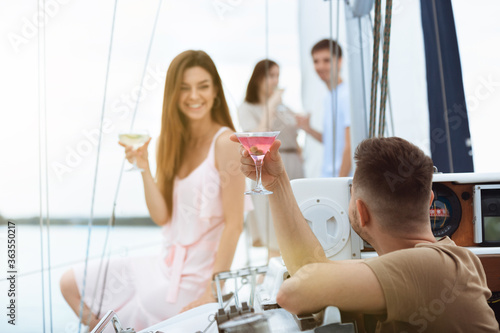 Canvas Print Happy smiling couple drinking vodka cocktails at boat party outdoor, cheerful and happy