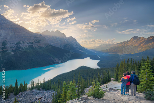 a family of hikers observing sunset over Peyto lake in Canada