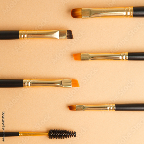 Set of gold and black brow brushes concept. Makeup artist's brushes on an isolated background. photo