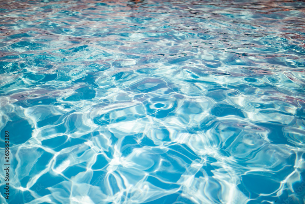 Clear shiny and warm blue water in the pool reflected in it by the rays of the sun in anticipation of tourists. Vacation and travel concept. Advertising space Clear shiny and warm blue water in the pool reflected in it by the rays of the sun in anticipation of tourists. Vacation and travel concept. Advertising space